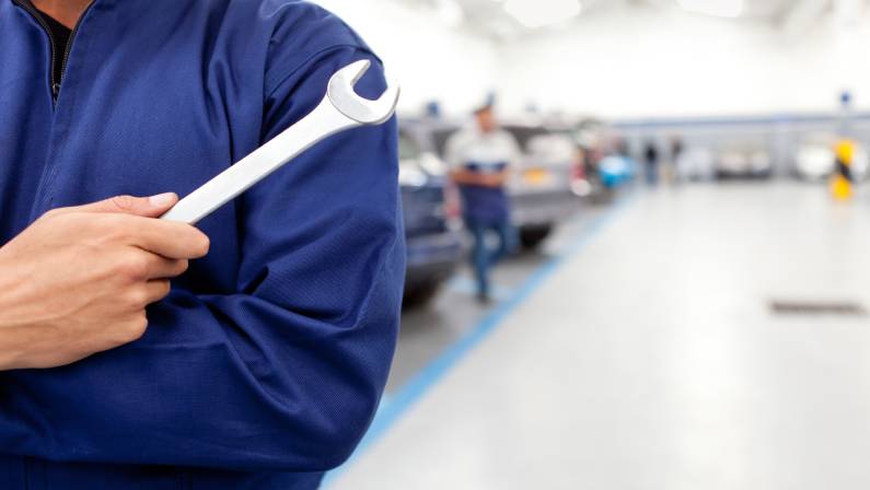 Hand of car mechanic with wrench.