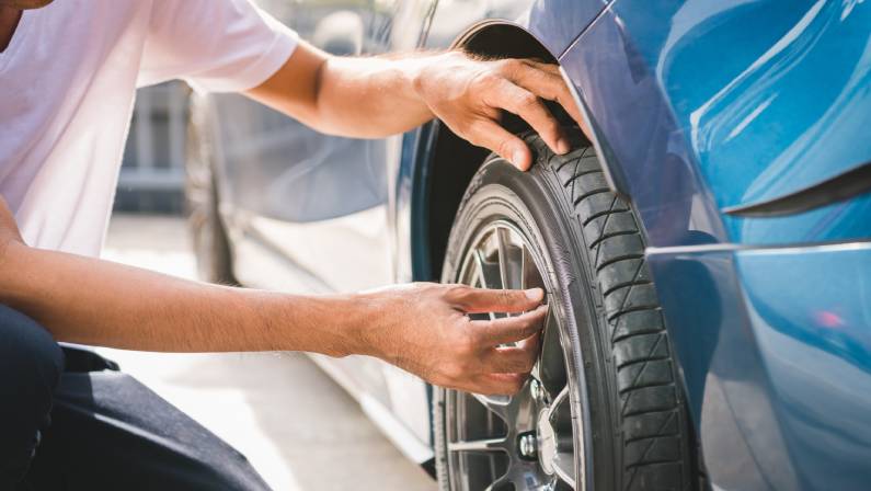 Closeup male automotive technician checking wheel alignment