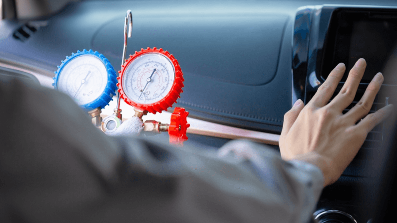 Repairman holding monitor tool to check and fixed car air conditioner system.