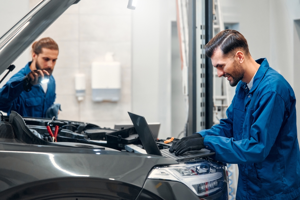 Two mechanics are repairing a car in a workshop