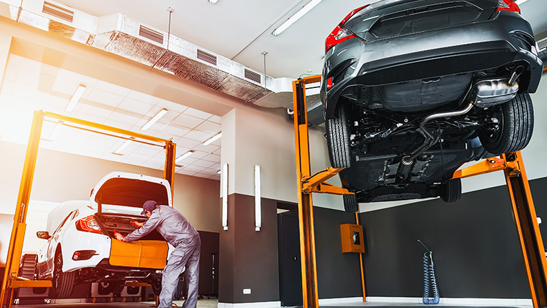 Precise Vehicle Care. Hydraulic Machine Lifting Modern Japanese Car for Inspection.