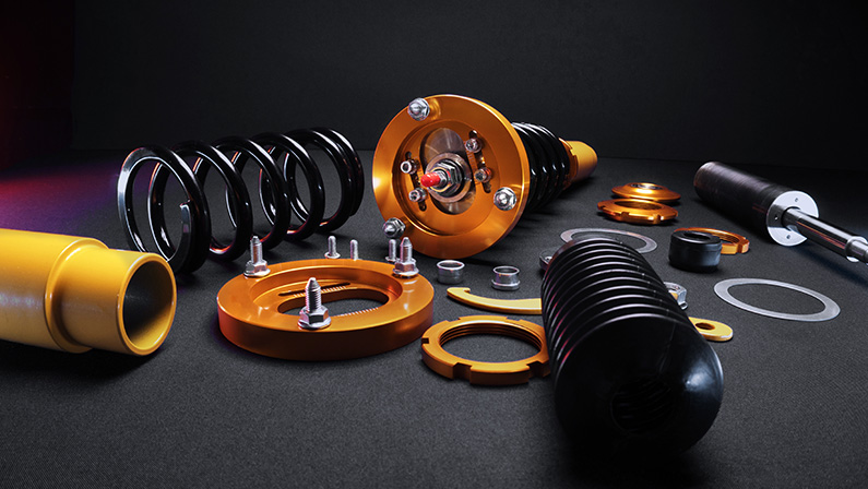 suspension tuning, coilovers, shock absorbers and front springs in yellow and gold colors for a sports drift car on a dark background