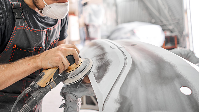 The mechanic works with a grinding tool.