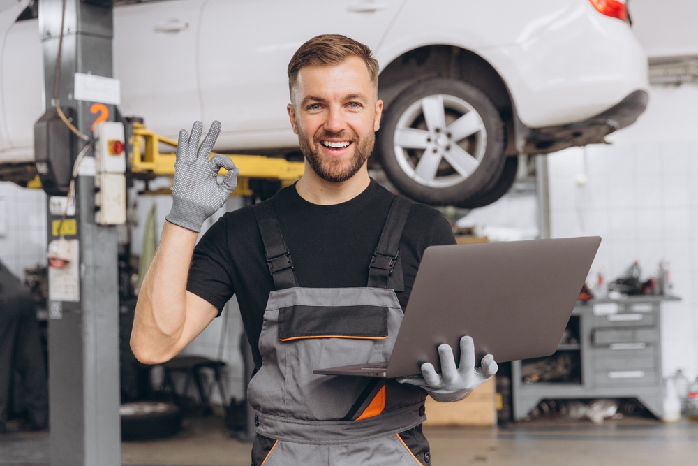 Mechanic fixing, repairing automobile lifted behind.